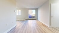 Located at 122 Bronte St S in Milton, Ontario, this 2-bedroom, 1-bathroom unit offers a clean, modern aesthetic throughout. Light-toned hardwood-style flooring flows seamlessly across the entire space, complementing the crisp white walls and trim that create a bright, welcoming atmosphere.

The kitchen features stainless steel appliances, white cabinetry, and ample counter space, opening toward a dedicated dining area. The combined living and dining area is generously sized, flooded with natural light through large sliding glass doors that lead directly to a private balcony. From the balcony, elevated views of the surrounding Milton landscape and greenery can be enjoyed.

Both bedrooms are well-proportioned and bathed in natural light from large windows that frame outdoor views. The primary bedroom includes closet access and connects conveniently to the rest of the unit. Three closets throughout the unit provide excellent storage options.

The bathroom is finished with white subway-tiled walls surrounding a full soaker tub and shower, complemented by a stone-topped vanity and grey tile flooring. The overall design of the unit is clean and contemporary, making it a comfortable and functional home in the heart of Milton.