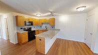 Located at 3861 Sylvan Lakes Blvd in Sylvania, Ohio, this 2-bedroom, 3-bathroom single-floor residence offers a well-designed layout with consistent finishes throughout. The open-concept kitchen and living area serves as the heart of the home, featuring warm honey-toned cabinetry, granite countertops, a speckled tile backsplash, and a peninsula that provides additional prep space and separates the kitchen from the living area. Black appliances including a range and built-in microwave complete the kitchen. Hardwood-style flooring runs throughout the main living spaces, adding warmth and continuity. The living room is generously sized and receives natural light through a large sliding glass door that opens to an outdoor area. Both bedrooms offer hardwood-style flooring, ample natural light from large windows, and closet storage. The primary bedroom is a comfortable size with two windows overlooking the exterior. The three bathrooms feature granite-topped vanities with warm wood cabinetry and tile flooring, with at least one bathroom equipped with a shower-tub combination. A dedicated utility room rounds out the functional layout of this well-appointed residence.