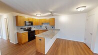 Located at 3861 Sylvan Lakes Blvd in Sylvania, Ohio, this 2-bedroom, 3-bathroom single-floor residence offers a well-designed layout with consistent finishes throughout. The open-concept kitchen and living area serves as the heart of the home, featuring warm honey-toned cabinetry, granite countertops, a speckled tile backsplash, and a peninsula that provides additional prep space and separates the kitchen from the living area. Black appliances including a range and built-in microwave complete the kitchen. Hardwood-style flooring runs throughout the main living spaces, adding warmth and continuity. The living room is generously sized and receives natural light through a large sliding glass door that opens to an outdoor area. Both bedrooms offer hardwood-style flooring, ample natural light from large windows, and closet storage. The primary bedroom is a comfortable size with two windows overlooking the exterior. The three bathrooms feature granite-topped vanities with warm wood cabinetry and tile flooring, with at least one bathroom equipped with a shower-tub combination. A dedicated utility room rounds out the functional layout of this well-appointed residence.