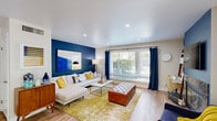 Located in Fresno, CA, this two-story home offers 2 bedrooms and 4 bathrooms across two thoughtfully designed floors. Light hardwood flooring flows throughout, complementing a bright, neutral palette accented by bold design choices in key rooms.

The main floor opens to a welcoming living room featuring recessed lighting, a striking navy accent wall, and large windows that fill the space with natural light. The adjacent dining area connects seamlessly to a private patio via sliding glass doors, while a stylish pendant light anchors the dining space. The galley-style kitchen is well-equipped with stainless steel appliances, dark granite countertops, white shaker cabinetry, and a window overlooking greenery.

Upstairs, the spacious primary bedroom features dual closets, a ceiling fan, and generous natural light. A second bedroom stands out with a bold geometric accent wall, an arched window, and a ceiling fan. Both bedrooms are served by bathrooms finished with granite-topped white vanities. Additional bathrooms feature tub/shower combinations with tile flooring.

The attached garage is a standout feature, boasting a classic black-and-white checkered floor, built-in workbench, and an automatic opener. An exterior metal staircase with black railings leads between floors, surrounded by lush landscaping.