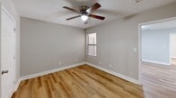 Located at 7933 Old Sylacauga Hwy in Childersburg, Alabama, this 2-bedroom, 2-bathroom unit offers a clean, modern aesthetic across a practical single-floor layout. Light wood-style flooring flows consistently throughout the space, complementing the neutral gray wall tones and bright white trim found in every room.

The kitchen features white shaker-style cabinetry, granite-look countertops, a stainless steel sink, a dishwasher, and a stainless steel refrigerator — all thoughtfully arranged in a galley configuration that maximizes efficiency.

Both bedrooms are comfortably sized, with the primary bedroom offering a generous footprint. Each room is equipped with a ceiling fan with light fixture and windows fitted with blinds that allow for natural light and outdoor views. The primary bedroom includes direct access to one of the two bathrooms, which is outfitted with a full tub/shower combination, toilet, and vanity. The second bedroom features closet access and is serviced by the additional full bathroom, which mirrors the same clean, white finishes including a tub/shower unit and wood-style flooring.

The overall ambiance is bright and move-in ready, with a cohesive design language that prioritizes functionality and simplicity throughout.