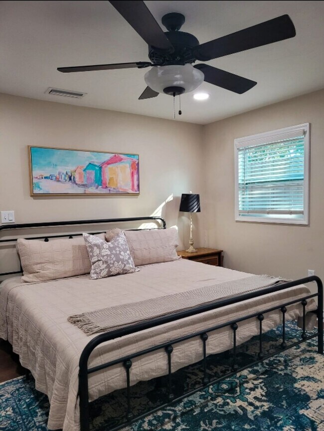 El dormitorio principal cuenta con una cama King, un televisor inteligente de 40" y un armario. - 4444 17th St W