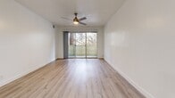 Located at 780 Oak Grove Rd in Concord, California, this two-bedroom, two-bathroom residence offers a clean, modern aesthetic throughout its single-floor layout. Light wood-style flooring flows continuously across the living spaces, complementing the bright white walls and creating a fresh, cohesive look.

The open-concept kitchen, dining, and living area serves as the heart of the home. The kitchen features white shaker cabinetry, light quartz countertops, a curved peninsula with an integrated sink, and a full suite of stainless steel appliances including a refrigerator, electric range, and over-the-range microwave. Built-in open shelving adds functional storage and visual interest adjacent to the kitchen.

Sliding glass doors in the living area open to a private balcony framed by mature trees, bringing natural light and outdoor views into the space. Both bedrooms are well-proportioned, with the spacious primary bedroom offering ample room for furnishings. Each bedroom includes a ceiling fan and window with natural light. Three closets provide generous storage throughout.

The two bathrooms are finished in clean, neutral tones with light wood-style flooring, white vanities with brushed nickel hardware, and one full bath featuring a soaking tub with shower. The overall ambiance is bright, modern, and move-in ready.