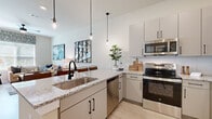 Located in Sugar Hill, GA, this thoughtfully designed one-bedroom, one-bathroom residence offers a cohesive open-concept layout that seamlessly connects the kitchen, dining, and living areas. The kitchen is a standout, boasting granite countertops, a large island with seating, stainless steel appliances including a refrigerator, range, microwave, and dishwasher, complemented by sleek gray cabinetry and a white tile backsplash. Pendant lighting adds a stylish touch above the island. The combined living and dining area is bright and welcoming, with large windows that invite abundant natural light and views of the outdoors. Light wood-look flooring runs throughout the main living spaces, while a ceiling fan adds comfort. The bedroom is a serene retreat with plush carpet, generous windows framing outdoor greenery, and a warm, neutral palette. The bathroom features granite countertops, a tub-shower combination with marble-style tile surround, and matching gray cabinetry, maintaining design continuity throughout the home. Clean lines, neutral tones, and modern fixtures define the overall aesthetic of this well-appointed residence.