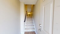 Located in Seven Fields, PA, this well-appointed three-bedroom, two-bathroom townhome is spread across three floors, offering generous living space and thoughtful layout throughout. The entry-level garage provides convenient interior access and ample storage. The main living floor features two distinct living areas, one dressed in rich hardwood-style flooring that lends warmth and continuity to the open layout. The kitchen is a standout, outfitted with dark espresso cabinetry, granite countertops, stainless steel appliances including a refrigerator, range, microwave, and dishwasher, plus recessed lighting and a window that invites natural light. A half bathroom on this level features a pedestal sink, oval mirror, and wood-look flooring. Upstairs, the upper floor is home to all three bedrooms, each carpeted for comfort. The generously sized primary bedroom offers a large closet and convenient access to a full bathroom. The additional bedrooms feature neutral tones, carpet flooring, and windows with outdoor views of the surrounding community. The full bathroom includes a dark-vanity with white countertop and a tub-shower combination. Multiple staircases connect the floors seamlessly, and the community exterior presents well-maintained landscaping in a quiet suburban setting.
