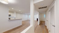 Located in the desirable West Los Angeles neighborhood of 90025, this single-floor unit at 1945 Glendon Ave offers a clean, modern aesthetic throughout. Light-toned hardwood floors extend seamlessly across every room, complementing the crisp white walls and creating a bright, airy atmosphere.

The open-concept living and dining area is a standout feature, anchored by a classic fireplace with a dark wood surround. Recessed lighting illuminates the generous open floor plan, while multiple windows allow natural light to fill the space. A peninsula with a built-in sink connects the living area to the kitchen, which is outfitted with white cabinetry, light countertops, a gas range, stainless steel appliances, and a black refrigerator. A window above the kitchen sink brings in additional natural light.

The bedroom offers a comfortable, well-proportioned layout with a large window and a built-in closet. The bathroom features a sleek white vanity with stone countertops, mirrored sliding closet doors, and a glass-enclosed tub and shower combination with tile surround. Throughout the unit, the design is consistent and cohesive, favoring a neutral palette that maximizes the sense of light and space. A dedicated hallway provides a clear entry sequence, adding to the functional flow of this well-appointed home.