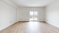 Located at 405 Park Rd N in Brantford, Ontario, this well-appointed 2-bedroom, 1-bathroom unit offers a practical and comfortable layout across a single floor. Light wood laminate flooring runs throughout the space, creating a bright and cohesive aesthetic.

The open-concept living and dining area is a standout feature, offering generous proportions and a sliding glass door that leads to a private balcony with scenic outdoor views. A chandelier adds a touch of warmth to the dining area, which connects to the kitchen via a pass-through window. The kitchen is equipped with warm wood cabinetry and ample storage, including a tall pantry-style cabinet.

The primary bedroom is a comfortable size and features a walk-in closet with wire shelving, providing excellent storage capacity. The second bedroom is bright and well-proportioned, with a sliding door closet and a window that brings in natural light. Both bedrooms are finished with the same light wood flooring found throughout the unit.

The bathroom includes a full tiled tub-shower combination, complemented by wood-toned flooring. Additional conveniences include a dedicated laundry area and multiple closets accessible from the hallway. The unit's clean, neutral palette and functional layout make it a practical and inviting living space.