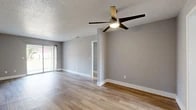 Located at 5327 Timuquana Rd in Jacksonville, FL, this single-story 2-bedroom, 1-bathroom home offers a clean, modern aesthetic with thoughtfully updated finishes throughout. Light wood-style flooring runs continuously across the home, complementing the neutral gray walls and crisp white trim for a cohesive, contemporary look.

The living room serves as the heart of the home, featuring a ceiling fan with integrated lighting, a textured ceiling, and a sliding glass door that opens to the outdoors, allowing abundant natural light to fill the space. The kitchen is well-equipped with white shaker-style cabinetry, light quartz countertops, a classic white subway tile backsplash, and stainless steel appliances including a range and dishwasher, all illuminated by a window above the sink.

Both bedrooms are comfortably sized, each outfitted with ceiling fans, natural light from windows with blinds, and ample closet access via two dedicated closets in the home. The primary bedroom offers a generous footprint suitable for a full furniture arrangement. The bathroom features a full tub-shower combination with white tile surround. Two hallways connect the spaces efficiently, contributing to the home's practical, functional flow throughout.
