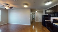 This single-floor, three-bedroom, two-bathroom residence offers a well-organized layout designed for comfortable everyday living. The open living and dining area features gleaming hardwood-style flooring that extends throughout the main living spaces, complemented by flush-mount ceiling lighting that keeps the area bright and welcoming. A hallway connects the main living area to the bedrooms and leads to an in-unit washer hookup, adding convenient laundry access.

The kitchen is outfitted with rich dark cabinetry reaching to the ceiling for ample storage, light-toned countertops, a double-basin sink, and a full suite of black appliances including a range, over-the-range microwave, dishwasher, and refrigerator. The functional design makes efficient use of the available space.

Each of the three bedrooms features plush carpet flooring, neutral-toned walls, and windows fitted with blinds that allow natural light to filter in. Ceiling fans in the bedrooms add comfort year-round. The panel-style doors throughout the unit lend a clean, consistent aesthetic.

The two bathrooms are finished with tile flooring, dark vanity cabinetry, white countertops, and brushed nickel fixtures. One bathroom includes a full tub-shower combination, while the other features a vanity with a large mirror and well-placed lighting. Both bathrooms maintain a clean, understated style throughout.