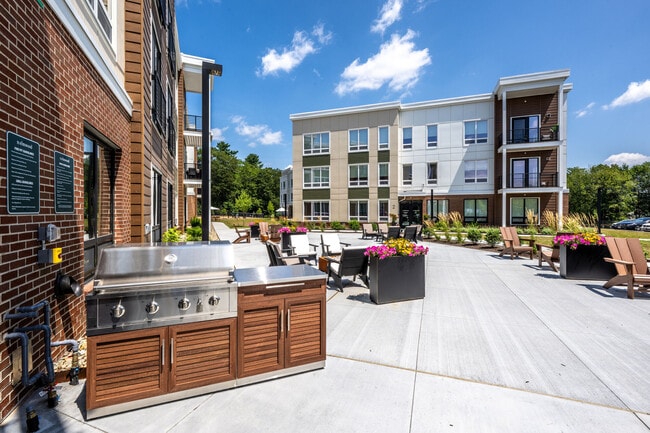 Outdoor grilling stations and gathering spaces at The Elmwood Apartments. - The Elmwood