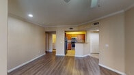 This single-floor residence offers a thoughtfully designed layout that balances functionality and comfort throughout. The open living area serves as the heart of the home, showcasing rich hardwood-style flooring, crown molding, and recessed lighting that create a polished, inviting atmosphere. Large windows fitted with blinds allow natural light to filter in, brightening the warm, neutral-toned walls found throughout the space.

The kitchen is well-equipped with warm wood cabinetry, granite countertops, a full suite of stainless steel appliances including a refrigerator, range, and microwave, and light tile flooring. A peninsula counter connects the kitchen to the main living area, making it ideal for both everyday use and entertaining.

The bedrooms are generously sized, each featuring the same hardwood-style flooring, ceiling fans with light fixtures, and windows that provide natural light and outdoor views. The rooms offer a calm, neutral palette well-suited for a variety of uses.

Both bathrooms are finished with tile flooring, wood vanity cabinetry, granite countertops, and tiled tub-shower combinations accented with warm tan tile banding. A dedicated in-unit laundry room houses a full-size washer and dryer, adding everyday convenience to this well-rounded residence.