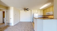 Located in Pittsburg, California (94565), this single-floor home offers a well-designed layout that balances comfort and functionality. The living area is a standout, featuring soaring vaulted ceilings with exposed beams, a ceiling fan, and plush wall-to-wall carpeting. A striking arched window floods the space with natural light, while a classic fireplace with a tile surround and white mantle serves as the room's focal point. Sliding glass doors open to an outdoor patio, offering pleasant views of surrounding greenery.

The kitchen is thoughtfully equipped with white cabinetry that extends to the ceiling, providing ample storage, complemented by granite-toned countertops, tile flooring, and a full suite of white appliances including a refrigerator, range, microwave, and dishwasher. A peninsula counter connects the kitchen to the living area, creating a natural open-concept flow.

The bedroom is generously sized with soft carpeting and a large window that frames outdoor tree views, offering a calm and private retreat. The bathroom features clean tile work and a shower-tub combination. A dedicated in-unit laundry closet with full-size washer and dryer hookups adds everyday convenience to this well-appointed home.