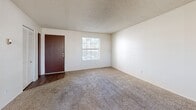 Located at 333 W Roger Rd in Tucson, Arizona, this single-story, 2-bedroom, 2-bathroom residence offers a practical and functional layout. The combined kitchen and living area forms the heart of the home, with the open-plan design creating a comfortable, connected space. The living room features neutral carpet flooring, a textured ceiling, and a window that brings in natural light. The kitchen is equipped with warm wood-tone cabinetry both above and below the countertops, white appliances including an electric range and dishwasher, and a stainless steel sink — all accessible via a charming glass-paned entry door. Both bedrooms are carpeted and offer generous proportions, with the primary bedroom providing ample space for a full suite of furniture. Each bedroom includes a closet with sliding or bifold doors for storage. The two bathrooms are well-appointed, each featuring wood-tone vanity cabinetry, a single sink with a lighted mirror, and a tub-shower combination with neutral tile surround and wood-look flooring. A hallway connects the bedrooms and bathrooms, completing the efficient single-floor floor plan. The consistent use of warm wood tones throughout the cabinetry and doors gives the residence a cohesive, classic aesthetic.