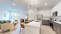 Located at 321 Main St. in Hackensack, NJ, this thoughtfully designed one-bedroom, one-bathroom residence offers a bright and contemporary living experience across a single floor. The open-concept layout seamlessly connects the kitchen, dining, and living areas, creating a cohesive and functional space bathed in natural light from large floor-to-ceiling windows.

The kitchen is a standout feature, showcasing a generous quartz-topped island with an undermount sink and pendant lighting overhead. Two-tone cabinetry — white uppers paired with gray lower cabinets — is complemented by a white subway tile backsplash and a full suite of stainless steel appliances. Light wood-style flooring runs throughout, enhancing the clean, modern aesthetic.

The living room offers a welcoming atmosphere with ample natural light streaming in through expansive windows. The adjacent dining area provides a defined space for meals without disrupting the open flow of the layout.

The bedroom is a calm, understated retreat featuring a sliding double-door closet, a window with an outdoor view, and the same warm flooring found throughout the residence.

The bathroom is finished in crisp white tile, featuring a soaking tub with shower, a white vanity with a framed mirror, and polished chrome fixtures — delivering a clean, spa-inspired feel.