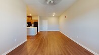 Located at 170 SR-113 in Carrollton, Georgia, this single-floor residence offers a well-designed layout that balances functionality and comfort throughout its living spaces. The open-concept living and dining area is finished with warm hardwood-style flooring and fitted with a ceiling fan, while large windows allow natural light to fill the room and provide views of the surrounding area. The kitchen is a central highlight, featuring rich wood cabinetry that extends to the ceiling for ample storage, light-toned countertops, black appliances including a range, refrigerator, and dishwasher, and a peninsula island with a built-in sink — ideal for both cooking and casual dining. A hallway off the kitchen leads to additional rooms and utility areas, including in-unit laundry access. The bedrooms are carpeted for comfort and each include a ceiling fan and window with natural light. The bathroom is generously proportioned, finished with neutral tile flooring, a vanity with wood cabinetry, and a shower with a curtain rod. Throughout the residence, a consistent neutral color palette, clean white trim, and recessed lighting create a cohesive and move-in-ready atmosphere.