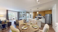 Located at 7777 Westside Dr in San Diego's Mission Valley neighborhood, this modern single-story residence offers a thoughtfully designed open-concept layout with contemporary finishes throughout. The living and dining areas flow seamlessly together, anchored by warm wood-style flooring and an abundance of natural light. The kitchen is a standout feature, boasting sleek bamboo-textured cabinetry, white quartz countertops, stainless steel appliances including a gas range, microwave, and refrigerator, and a peninsula with pendant lighting—ideal for both cooking and casual dining. The open layout connects directly to the dining and living areas, creating an inviting, social atmosphere. The primary bedroom is generously sized with plush carpeting, large windows framing palm tree views, and access to a well-appointed bathroom featuring wood-toned vanity cabinetry, a soaking tub, and a spacious walk-in closet with built-in shelving. A second bedroom also enjoys palm tree views through wide windows and soft carpeted flooring. The second full bathroom mirrors the modern aesthetic with a tub-shower combo and warm wood vanity. A private entry with a glass-panel door and outdoor space completes this well-appointed San Diego residence.