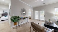 Located in Norcross, GA, this single-floor residence offers a thoughtfully designed layout that maximizes comfort and functionality. The open-concept kitchen and living area serves as the heart of the home, featuring dark espresso cabinetry, stainless steel appliances, a subway tile backsplash, and a marble-topped island that anchors the space. Rich hardwood-style flooring flows through the kitchen, transitioning to plush carpet in the living and bedroom areas. The living room is bright and welcoming, with crown molding, a ceiling fan, and large windows and French doors that invite natural light and outdoor views. The spacious bedroom offers a comfortable retreat with generous natural light and direct access to the full bathroom, which includes a shower-tub combination and dark vanity cabinetry. A dedicated office nook provides a quiet workspace with built-in desk storage. The in-unit laundry room features hardwood-style flooring, wire shelving overhead, and hookups for both washer and dryer. A walk-in closet adds practical storage. Neutral tones throughout create a clean, modern ambiance that is both versatile and inviting.