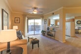 Located at 26630 Barton Rd in Loma Linda, California, this single-floor residence offers a thoughtfully designed layout with a comfortable and functional flow throughout. The living room serves as the heart of the home, featuring plush carpeting, crown molding, a ceiling fan, and sliding glass doors that open to a private balcony — allowing natural light to fill the space. The room transitions seamlessly toward the dining area and kitchen beyond.

The galley-style kitchen is efficiently arranged with warm wood cabinetry, light countertops, tile flooring, a double basin sink, and a full suite of white appliances, including a range, microwave, dishwasher, and refrigerator. A window above the counter brings in additional natural light.

The dining area adjoins a convenient in-unit laundry space equipped with a full-size washer and dryer — a practical and desirable feature. Crown molding adds a refined touch to this area as well.

The bedrooms are carpeted and comfortably sized, each featuring ceiling fans and windows that provide natural light and ventilation. The primary bedroom includes access to a walk-in closet. The bathroom is cleanly finished with tile flooring, a wood-toned vanity, and a full tub and shower combination. The overall ambiance throughout the residence is calm, neutral, and move-in ready.