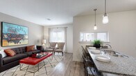 Located in the heart of Kansas City, this single-floor residence at 228 W 4th St offers a thoughtfully designed open-concept layout that seamlessly connects the kitchen, dining, and living areas. The kitchen is a standout feature, outfitted with dark espresso cabinetry, granite countertops, stainless steel appliances including a range, microwave, and refrigerator, and a peninsula breakfast bar with industrial-style metal seating — ideal for both casual dining and entertaining. Pendant lighting adds a modern touch overhead, while natural light pours in through multiple windows. The living area provides a comfortable and well-proportioned space with warm hardwood-style flooring, large windows dressed with patterned curtains, and ample room for relaxed seating arrangements. The bedroom features plush carpeting, a ceiling fan, generous closet space, and a calm, neutral palette. A second closeted bedroom or flex space offers additional versatility. The bathroom is clean and functional, featuring a granite-topped vanity with dark cabinetry, a full tub-shower combination, and hardwood-style flooring. Throughout the residence, a cohesive neutral color scheme, contemporary fixtures, and quality finishes create a polished and inviting atmosphere.