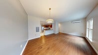 This two-bedroom, two-bathroom residence in Hartford, CT spans two floors, offering a well-organized and functional layout. The main level opens into a spacious living area featuring warm hardwood flooring, neutral-toned walls, and a stylish pendant light fixture. A wall-mounted mini-split system provides efficient climate control. The kitchen is seamlessly connected to the living space via a peninsula breakfast bar, and is equipped with stainless steel appliances, rich wood cabinetry, and track lighting overhead. Marble-look tile flooring flows through the hallway and bathrooms on this level, lending a clean, polished feel. The full bathroom on the main floor features a double-sink vanity with granite countertops, warm wood cabinetry, and a tub-shower combination. The upper floor hosts both bedrooms, each featuring plush carpeting and distinctive vaulted ceilings that add architectural character. Natural light filters in through multiple windows, offering views of the surrounding neighborhood. The primary bedroom includes a wall-mounted mini-split unit. Throughout the home, an impressive six closets provide exceptional storage. A staircase connects both levels, completing this well-appointed two-story home.
