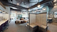 Located at 425 Hillsborough St in Chapel Hill, NC, this single-floor space blends industrial design with contemporary comfort to create a dynamic, multi-functional environment. Exposed ductwork and dark ceilings contrast beautifully with white walls and warm accent lighting, lending the space a sophisticated urban character throughout.

The open layout offers a variety of seating arrangements to accommodate different needs. A central lounge area features plush neutral sofas and ottomans, while high-backed upholstered booth seating provides more intimate, semi-private areas for focused conversation or work. A separate dining-style section includes structured booth seating with dark wood paneling and ample table space, ideal for group gatherings.

Collaborative workstations with task chairs line brick-accented walls, and built-in countertop work surfaces offer additional workspace options. The flooring transitions between warm wood-look tile and patterned carpet, subtly defining different zones within the open plan.

A standout rustic sliding barn door with glass panels adds architectural character and connects distinct areas of the space. Natural light pours in through large windows, and French doors open directly to an outdoor patio area, extending the usable space and providing a refreshing indoor-outdoor connection. Curated artwork and decorative accents complete the inviting, well-appointed atmosphere.