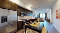 Located at 6636 Variel Ave in the Canoga Park neighborhood of Los Angeles, this single-floor residence offers a thoughtfully designed open-concept layout with modern finishes throughout. The kitchen serves as a central highlight, featuring floor-to-ceiling dark espresso cabinetry, stainless steel appliances including a gas range, built-in microwave, and French door refrigerator, complemented by a stone tile backsplash and crisp white countertops. A dining area sits adjacent to the kitchen, flowing seamlessly into a bright living space with access to an outdoor balcony. The bedroom is generously proportioned, benefiting from large windows that allow abundant natural light, and includes a double-door closet. Tall ceilings in the bedroom enhance the sense of openness. Two bathrooms are finished with light stone-look tile flooring and dark wood vanities; one includes a full soaking tub with shower, while the other features a sleek illuminated mirror above a modern vanity. Wood-look plank flooring runs throughout the main living areas, adding warmth to the contemporary aesthetic. The residence also includes a dedicated hallway area with wall space well-suited for display, rounding out a well-organized and stylish single-level home.