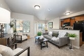 Located at 8448 W Limelight St in Boise, Idaho, this single-story, 2-bedroom, 2-bathroom home offers a thoughtfully designed open-concept floor plan that maximizes every square foot. The living room features plush carpeting, a textured ceiling, and multiple windows that flood the space with natural light, providing views of the surrounding greenery. It connects seamlessly to the dining area, which is highlighted by a stylish pendant chandelier and a large window, creating a warm and inviting atmosphere. The kitchen is equipped with warm wood cabinetry, dark granite countertops, a tile backsplash, black appliances, and a breakfast bar that opens to the living space — ideal for both everyday living and entertaining. The generously sized primary bedroom offers vaulted ceilings, large windows with outdoor views, and soft carpeting, creating a peaceful retreat. The second bedroom is equally comfortable, featuring ample natural light and well-proportioned closet space. Both bathrooms are clean and functional, with one featuring a full tub-shower combination. Additional highlights include three closets for plentiful storage, an in-unit laundry area, a private patio, and wood-look flooring in key areas. The overall ambiance is warm, neutral, and move-in ready.