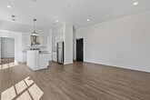 This well-appointed 1-bedroom, 2-bathroom residence offers a thoughtfully designed single-floor layout that maximizes functionality and comfort. Light hardwood flooring flows seamlessly throughout the entire space, complemented by crisp white walls and recessed lighting that create a bright, airy atmosphere.

The open-concept kitchen and living area serves as the heart of the home. The kitchen is a standout, featuring white shaker cabinetry, granite countertops, a subway tile backsplash, and a full suite of stainless steel appliances including a range with a wall-mounted hood, dishwasher, and refrigerator. A central island with pendant lighting provides additional prep space and casual seating. Sliding glass doors in the living area invite natural light and provide access to an outdoor balcony with neighborhood views.

The spacious bedroom is generously sized, with a ceiling fan, a large window with outdoor views, and access to a dedicated closet. Both bathrooms are finished consistently with granite vanity countertops, white cabinetry, and subway tile accents. One bathroom includes a tub/shower combination with a curved curtain rod. An in-unit stacked washer and dryer adds everyday convenience to this modern, move-in-ready residence.