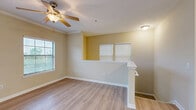 Located in Spanish Fort, Alabama, this well-appointed 2-bedroom, 2-bathroom residence offers a comfortable and functional single-floor layout. The open living and dining area is finished with light hardwood-style flooring, crown molding, and a ceiling fan, while multiple windows with blinds allow natural light to fill the space. A pendant chandelier adds a refined touch to the dining area, which also features direct exterior access.

The kitchen is equipped with warm wood cabinetry, granite countertops, a tile backsplash, black appliances including a side-by-side refrigerator with ice maker, electric range, and built-in microwave, all set atop durable tile flooring.

Both bedrooms are carpeted and include ceiling fans and generous closet space. The primary bedroom features a walk-in closet with wire shelving, providing ample storage. Each of the two full bathrooms is outfitted with granite-topped vanities, tile flooring, and a tub/shower combination with full tile surround and brushed nickel fixtures.

A dedicated laundry room houses a full-size washer and dryer set with additional wire shelving above. The neutral color palette and consistent finishes throughout create a cohesive, move-in-ready atmosphere well suited for everyday living.
