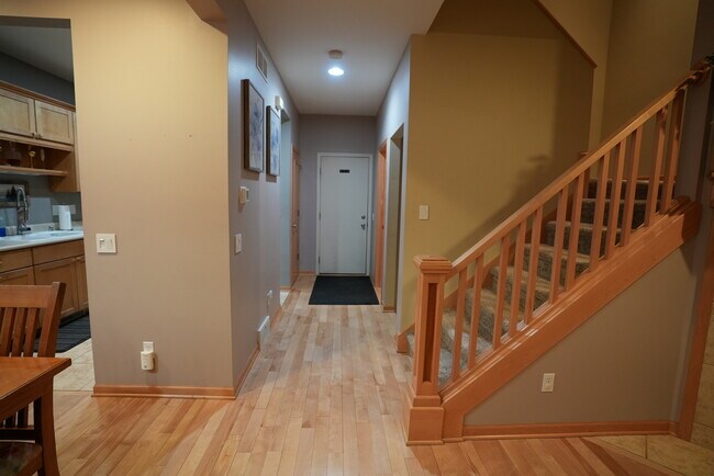 Main hallway connecting the kitchen, garage, basement, and upstairs living areas - 54 Wood Brook Way