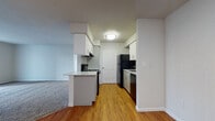 Located at 400 N Pebble Creek Terrace in Mustang, Oklahoma, this single-story unit presents a clean, functional layout with a neutral color palette throughout. The kitchen serves as a central feature, equipped with white cabinetry, a tiled backsplash, black appliances including a refrigerator, electric range, and dishwasher, and a peninsula counter that opens toward the living area. Durable hardwood-style flooring runs through the kitchen, providing a warm contrast to the bright white cabinetry and walls.

The living area is generously proportioned, finished with plush carpeting and neutral tones. A sliding glass door with vertical blinds allows natural light to fill the space while providing outdoor access. The carpeting continues into the bedroom, which features a wide window fitted with horizontal blinds, offering natural light and exterior views.

The bathroom includes a full tub and shower combination with a curved curtain rod, a vanity with white cabinetry and an integrated mirror, and warm-toned tile flooring. The overall design of the unit emphasizes a clean, move-in-ready aesthetic with consistent finishes, ample storage, and a practical, well-connected floor plan.
