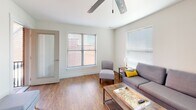 Located at 317 Fifth St in Lynchburg, Virginia, this single-floor unit offers a well-designed layout that balances comfort and functionality. The living area is bright and welcoming, featuring warm hardwood-style flooring, neutral walls, and multiple windows fitted with horizontal blinds that allow for excellent natural light. A ceiling fan adds to the room's practicality, while a glass-topped coffee table and access to an exterior door round out the space.

The kitchen is appointed with dark cabinetry, striking marble-patterned granite countertops, white subway tile backsplash, and stainless steel appliances including a range and dishwasher. The galley-style layout makes efficient use of the available space.

Two bedrooms each feature hardwood-style flooring, ceiling fans, and large windows that bring in natural light and offer views of the surrounding neighborhood. Both rooms accommodate substantial furniture and are finished with the same clean, neutral palette found throughout the unit.

The bathroom is well-equipped with a dark wood vanity, a large wall mirror, white countertop, tiled flooring, and a shower/tub combination enclosed by a decorative curtain. Overall, the unit presents a clean, move-in-ready environment with cohesive finishes and a practical, comfortable design throughout.