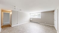 Located at 1 White Pine Cir in Fairport, NY, this two-bedroom, one-bathroom unit offers a straightforward and functional single-floor layout. The interior features a neutral, warm-toned color palette throughout, creating a clean and cohesive atmosphere.

The spacious primary bedroom is generously sized, with soft carpeting, a large closet with bifold doors, and a window that brings in natural light. The second bedroom mirrors the same carpeted flooring and neutral walls, also featuring a window with views of the surrounding area and a baseboard heating unit for year-round comfort.

The main living area is open and airy, with tile flooring, a large window that fills the space with natural light, and a baseboard heater. Track lighting is present, adding functional overhead illumination. A set of double doors in the living area provides additional storage.

The bathroom is well-appointed with a white shaker-style vanity with under-cabinet storage, a white countertop, a mirrored medicine cabinet, and light tile flooring. The clean, bright finishes give the bathroom a crisp and tidy feel.

Overall, this unit presents a practical and comfortable living space with consistent finishes, ample natural light, and convenient storage throughout — all within the welcoming community of Fairport, NY.