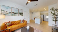 Located in Boerne, TX, this single-story 2-bedroom, 2-bathroom residence offers a thoughtfully designed open-concept layout. The combined kitchen and living area serves as the heart of the home, where light wood-tone flooring, recessed lighting, and a ceiling fan create a bright and inviting atmosphere. Large windows flood the living room with natural light while providing outdoor views, complemented by clean white walls throughout.

The kitchen is well-equipped with stainless steel appliances, including a refrigerator, range, and over-the-range microwave. Grey shaker-style cabinetry with black hardware pairs with white quartz countertops and a classic subway tile backsplash. A central island with pendant lighting above offers bar seating for two.

The primary bedroom is a comfortable retreat with plush carpeting, a ceiling fan, and a spacious closet. The primary bathroom features a double-sink vanity with white quartz countertops, grey cabinetry with black hardware, a walk-in shower, and additional storage. The second bedroom also features carpeting, a ceiling fan, and a bright window. Additional highlights include a dedicated laundry area, utility room, hallway, and a patio, rounding out a practical and modern living space.