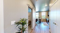 Located at 412 3rd St E in Hastings, MN, this efficiently designed one-bedroom, one-bathroom unit makes excellent use of its compact footprint. The open-concept kitchen and living area forms the heart of the space, featuring rich, dark-stained cabinetry, striking granite countertops, and a full suite of stainless steel appliances including a refrigerator, electric range, dishwasher, and microwave. Light wood-tone flooring runs throughout the main living areas, adding warmth and continuity. Large windows flood the kitchen and living room with natural light and offer views of the surrounding greenery, while a sliding glass door provides direct access to a private balcony — a standout feature ideal for enjoying the outdoors. A stylish sliding barn door separates the bedroom from the main living area, offering both privacy and a modern design touch. The bedroom features plush carpeting and a built-in closet, creating a cozy and functional retreat. The bathroom is finished with a dark-toned vanity topped with granite, a framed mirror, and wood-look tile flooring, maintaining a cohesive aesthetic throughout. Neutral gray tones across all rooms contribute to a calm, contemporary ambiance that feels open and inviting.