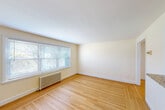 Located at 41 Garden City Drive in Cranston, Rhode Island, this well-maintained 2-bedroom, 1-bathroom single-floor home offers a thoughtfully laid-out floor plan with a clean, bright aesthetic throughout. Warm hardwood floors flow through the bedrooms and living areas, complementing the soft, neutral wall tones that give the space a welcoming ambiance.

The kitchen stands out as a highlight of the home, featuring white shaker-style cabinetry, granite countertops, a warm brick-pattern tile backsplash, and stainless steel appliances including a range, dishwasher, and refrigerator. A window above the sink allows natural light to fill the space, while wood-look tile flooring and beadboard wainscoting add a charming, cottage-like character.

Both bedrooms are comfortably sized, with the primary bedroom offering ample space and natural light. Each room features hardwood floors, ceiling fans with light fixtures, windows with exterior views, and cast iron radiators that provide efficient, classic heating.

The full bathroom is tastefully finished with white subway tile walls accented by black trim details, a classic mosaic tile floor, a tub-shower combination, and a bright window that enhances the clean, timeless design. A connecting hallway ties the layout together efficiently. This home combines classic architectural details with updated finishes for comfortable, functional living.