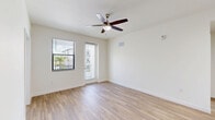 Located at 3681 Michigan Ave in Fort Myers, Florida, this single-floor, two-bedroom, two-bathroom unit offers a clean, modern aesthetic with a consistent design language carried throughout every room. Light wood-look flooring runs continuously across the entire unit, lending warmth and visual cohesion to the space.

The kitchen serves as a functional centerpiece, featuring white shaker-style cabinetry, light quartz countertops, a large island with an undermount sink, and a full suite of stainless steel appliances including a range, over-the-range microwave, and refrigerator. The open layout connects the kitchen to the living area, which includes a ceiling fan and access to an exterior door with sidelight windows that bring in natural light.

Both bedrooms are bright and well-proportioned, each equipped with ceiling fans and windows fitted with blinds that offer views of the surrounding community. The primary bedroom provides a comfortable footprint, while the second bedroom offers similar finishes and natural light.

The two bathrooms maintain the unit's clean, contemporary look with white cabinetry, light countertops, brushed nickel hardware, and tub-shower combinations. One bathroom features a longer vanity corridor layout, adding a sense of depth. A hallway and closet complete the floor plan, providing practical storage and circulation throughout the unit.