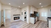 Located at 1015 Third St in Santa Monica, CA, this thoughtfully designed single-floor unit blends modern aesthetics with functional living. Light wood-style flooring runs throughout, creating a cohesive and airy feel across the entire space.

The main living area is anchored by a striking wall-mounted electric fireplace set against a full marble-look porcelain accent wall, adding both warmth and a bold design statement. Natural light filters in through windows that offer views of lush greenery, complemented by a wall-mounted mini-split system for year-round climate control.

The galley-style kitchen is outfitted with stainless steel appliances including a gas range, microwave, dishwasher, and refrigerator, paired with white cabinetry, dark quartz countertops, and a stainless sink — delivering a clean, contemporary finish. A dedicated in-unit laundry closet with a stacked washer and dryer adds everyday convenience.

The bathroom showcases a refined design with full marble-look tile in the glass-enclosed walk-in shower, large-format floor tile, a wall-mounted vanity with a white basin sink, and brushed nickel fixtures throughout. An additional room with recessed lighting and neutral walls offers flexible use as a bedroom or office. The space is modern, efficient, and move-in ready.
