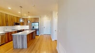 Located at 400 W Swedesford Road in Berwyn, PA, this well-appointed 2-bedroom, 2-bathroom residence offers a thoughtfully designed single-floor layout. The open-concept kitchen and living area serves as the heart of the home, showcasing warm wood-toned cabinetry, a white quartz waterfall island, stainless steel appliances including a French door refrigerator and built-in microwave, and stylish pendant lighting overhead. Light hardwood-style flooring flows throughout the living areas, complemented by abundant natural light from multiple windows and a private exterior door. The spacious primary bedroom features light-filled windows with outdoor views, plush carpeting, and a generous walk-in closet equipped with wire shelving. Its en-suite bathroom offers a sleek vanity with warm wood cabinetry, a white quartz countertop, an illuminated mirror, and a glass-door shower. The second bedroom is equally well-sized, with carpeted floors, a built-in closet with shelving, and natural light. The second bathroom features a classic subway-tiled tub and shower combo. Neutral tones throughout create a clean, modern aesthetic suited for comfortable everyday living.