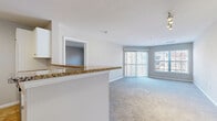 Located at 900 Crest Ln in Fort Lee, NJ, this well-appointed 2-bedroom, 2-bathroom residence offers a thoughtfully designed single-floor layout. The open-concept kitchen and living area serves as the heart of the home, where a granite-topped peninsula counter connects the two spaces seamlessly. The kitchen is equipped with stainless steel appliances—including a refrigerator, range, and dishwasher—white cabinetry, and warm tile flooring. The spacious living room is carpeted and filled with natural light from a large sliding glass door leading to an outdoor area, complemented by an additional picture window. A track lighting fixture and ceiling-mounted light add functional illumination throughout. Both bedrooms are generously sized with plush carpeting and natural light from exterior windows. The primary bedroom is notably spacious and includes access to a walk-in closet outfitted with wire shelving systems for organized storage. The two bathrooms feature tile flooring, white vanities with large mirrors, and brushed nickel fixtures; one includes a full soaking tub and shower combination. A connecting hallway ties all rooms together efficiently, creating a clean and functional flow throughout the residence.