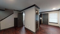 Located at 620 41st Ave N, Unit C in Nashville, TN, this multi-story property spans three floors and is finished with a consistent, cohesive design throughout. Dark hardwood flooring runs through the main living areas, complemented by bold dark crown molding and baseboards that create a striking contrast against neutral-toned walls.

The kitchen is well-appointed with dark espresso cabinetry, dark granite countertops, a double-basin sink, and stainless steel appliances including a refrigerator and range. A window provides natural light, and the layout offers ample counter and storage space. Adjacent to the kitchen, the main level also features a bathroom with tile flooring, a dark vanity, and a shower.

The staircase connects the floors seamlessly, with recessed lighting accenting the transition between levels. Bedrooms are carpeted for comfort, each featuring windows with blinds that allow natural light and views of surrounding greenery. One bedroom includes a ceiling fan and direct access to a full bathroom. Additional bathrooms throughout the property are finished with tile flooring, dark vanities, and well-lit mirrors.

The overall ambiance is clean and modern, with dark architectural accents providing a bold, intentional aesthetic throughout every level of this Nashville property.