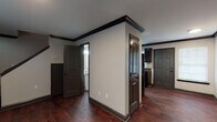 Located at 620 41st Ave N, Unit C in Nashville, TN, this multi-story property spans three floors and is finished with a consistent, cohesive design throughout. Dark hardwood flooring runs through the main living areas, complemented by bold dark crown molding and baseboards that create a striking contrast against neutral-toned walls.

The kitchen is well-appointed with dark espresso cabinetry, dark granite countertops, a double-basin sink, and stainless steel appliances including a refrigerator and range. A window provides natural light, and the layout offers ample counter and storage space. Adjacent to the kitchen, the main level also features a bathroom with tile flooring, a dark vanity, and a shower.

The staircase connects the floors seamlessly, with recessed lighting accenting the transition between levels. Bedrooms are carpeted for comfort, each featuring windows with blinds that allow natural light and views of surrounding greenery. One bedroom includes a ceiling fan and direct access to a full bathroom. Additional bathrooms throughout the property are finished with tile flooring, dark vanities, and well-lit mirrors.

The overall ambiance is clean and modern, with dark architectural accents providing a bold, intentional aesthetic throughout every level of this Nashville property.