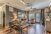 This single-floor residence showcases a thoughtfully designed interior with a cohesive blend of modern and warm contemporary finishes. The kitchen serves as a standout feature, boasting rich dark espresso cabinetry extending to the ceiling, granite countertops, a classic white subway tile backsplash, and stainless steel appliances. A central island with a undermount sink provides additional prep space, while pendant and track lighting illuminate the room effectively. Tile flooring runs throughout the kitchen and bathrooms, complementing the overall aesthetic.

The living area features hardwood-style flooring, crown molding, and a bold accent wall in deep teal, creating an inviting and stylish atmosphere. Multiple bedrooms offer plush carpeting, ceiling fans, natural light through well-dressed windows, and ample space for large furniture arrangements. Each bedroom carries its own distinct character while maintaining design consistency.

The bathrooms are finished with granite-topped dark vanities, tile flooring, and generous storage. The primary bathroom includes a dual-sink vanity, a walk-in closet, and a tiled shower with arched detailing. Bold black interior doors add a striking architectural contrast throughout the residence, tying together the refined and modern design sensibility.
