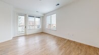 Located at 311 W 22nd St in Kansas City's vibrant Crossroads Arts District, this modern 2-bedroom, 2-bathroom unit offers a thoughtfully designed single-level layout. The open-concept living area seamlessly connects the dining room, kitchen, and living room, all finished with warm light wood flooring that runs throughout. The kitchen is a standout, featuring two-tone cabinetry — crisp white uppers paired with gray lower cabinets — a white subway tile backsplash, dark quartz countertops, stainless steel appliances, and a central island with a built-in sink, ideal for both cooking and entertaining. The primary bedroom offers generous proportions with views of the Kansas City skyline through large windows. The second bedroom features plush carpet and a window overlooking the surrounding urban landscape. A versatile den provides additional flexible space. Both bathrooms are clean and modern, with one featuring a full soaking tub surrounded by classic white subway tile. A dedicated hallway connects the private quarters, and the unit includes in-unit laundry and a utility room for added convenience. Abundant closet space and recessed lighting throughout complete this well-appointed urban residence.
