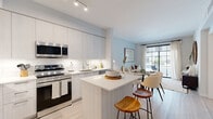 Located at 1711 N University Dr in Plantation, Florida, this single-floor residence showcases a thoughtfully designed open-concept layout with modern finishes throughout. Light wood-look flooring flows seamlessly across the entire space, lending warmth and visual continuity.

The kitchen is a standout feature, outfitted with flat-panel, light-wood cabinetry extending to the ceiling for generous storage, stainless steel appliances, a classic white subway tile backsplash, and crisp quartz countertops. A central island with bar seating serves as both a prep area and a casual gathering spot, connecting the kitchen to the adjacent dining and living areas.

The living room is bright and airy, with large sliding glass doors that invite natural light and provide access to an outdoor area with views of lush greenery. The space is open and versatile, flowing naturally into the dining area.

The bedroom is a calm retreat, featuring a window framed by sheer linen curtains that offer garden views and soft natural light. Light, neutral tones and clean lines create a tranquil atmosphere throughout.

The bathroom is finished in a crisp, all-white palette with a floating vanity, illuminated mirror, quartz countertop, and light wood flooring. An adjacent walk-in closet provides practical storage and organization. Overall, the residence offers a clean, contemporary aesthetic well-suited to modern living.