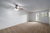 Located at 1210 Calle Jules in Vista, California, this single-floor residence offers two bedrooms and two full bathrooms within a thoughtfully arranged floor plan. The combined living and dining area serves as the heart of the home, featuring neutral carpet flooring, a ceiling fan with light fixture, and a textured ceiling. A glass-paned door opens to one of two balconies, allowing natural light to flow freely into the space. The kitchen is outfitted with warm wood cabinetry extending to the ceiling for ample storage, light countertops, a stainless steel range, and wood-look vinyl flooring. A pass-through opening connects the kitchen to the living area, enhancing the open feel. Both bedrooms are carpeted and include sliding-door closets, with the primary bedroom offering generous proportions and its own closet. The two bathrooms feature tub-shower combinations with sliding glass enclosures, wood-look vinyl flooring, and vanities with warm-toned cabinetry. With six closets distributed throughout, storage is a standout feature of this home. Two hallways connect the main living spaces to the private quarters, and the dual balconies provide outdoor access from multiple points in the residence.