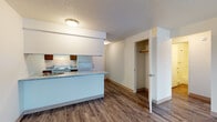 Located at 7007 North Nevada Street in Spokane, Washington, Unit 130 is a single-floor residence that combines practical design with comfortable living. The open-concept layout connects the kitchen and living area seamlessly, creating a cohesive and functional space throughout.

The kitchen is equipped with warm wood cabinetry, a white electric range, a full-size refrigerator, and a double-basin sink. A peninsula with a light-toned countertop extends into the living area, providing additional prep space and serving as a natural divider between the two zones. Durable wood-look vinyl plank flooring runs throughout the kitchen and main living areas, offering both aesthetic appeal and easy maintenance.

The living area is generously proportioned, featuring a sliding glass door that allows natural light to fill the room and provides a view to the outdoors. A baseboard heating system runs along the wall, ensuring year-round comfort. A closet positioned near the main entry offers convenient everyday storage.

The bedrooms are finished with plush carpeting and are each fitted with windows that bring in natural light and views of the surrounding neighborhood. Baseboard heaters are present in each room for consistent warmth.

The bathroom features a full tub-shower combination with clean white surrounds, a vanity, and wood-look tile flooring. Textured ceilings are consistent throughout the unit, completing the overall design.