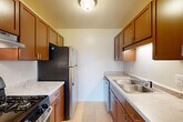 Located at 20205 Telegraph Rd in Romulus, MI, this single-floor, 2-bedroom, 1-bathroom unit offers a practical and comfortable layout. The carpeted living area is bright and inviting, featuring a ceiling fan and large sliding glass doors with vertical blinds that open to a private balcony, filling the room with natural light and outdoor views. Adjacent to the living area, the dining room provides a dedicated space for meals.

The galley-style kitchen is efficiently designed with warm wood cabinetry, light stone-look countertops, a double stainless steel sink, and stainless steel appliances including a gas range and refrigerator. Light tile flooring completes the clean, functional aesthetic.

The primary bedroom is generously sized with carpet flooring, a built-in closet, and hardwood-style flooring near the entry. The second bedroom also features plush carpeting and a bright window, with its own closet for storage. Additional closets throughout the unit provide further storage flexibility. The full bathroom is finished with large-format earth-toned wall tile surrounding a soaking bathtub. A hallway connects the rooms, rounding out a well-organized floor plan suited for everyday living.