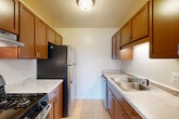 Located at 20205 Telegraph Rd in Romulus, MI, this single-floor, 2-bedroom, 1-bathroom unit offers a practical and comfortable layout. The carpeted living area is bright and inviting, featuring a ceiling fan and large sliding glass doors with vertical blinds that open to a private balcony, filling the room with natural light and outdoor views. Adjacent to the living area, the dining room provides a dedicated space for meals.

The galley-style kitchen is efficiently designed with warm wood cabinetry, light stone-look countertops, a double stainless steel sink, and stainless steel appliances including a gas range and refrigerator. Light tile flooring completes the clean, functional aesthetic.

The primary bedroom is generously sized with carpet flooring, a built-in closet, and hardwood-style flooring near the entry. The second bedroom also features plush carpeting and a bright window, with its own closet for storage. Additional closets throughout the unit provide further storage flexibility. The full bathroom is finished with large-format earth-toned wall tile surrounding a soaking bathtub. A hallway connects the rooms, rounding out a well-organized floor plan suited for everyday living.