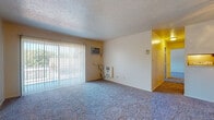 Located at 4298 Rocky River Dr in Cleveland, OH, this single-floor, 2-bedroom, 1-bathroom unit offers a functional and straightforward layout well-suited for comfortable everyday living. The living room is generously sized, featuring wall-to-wall carpeting, a textured ceiling, and a large sliding glass door dressed with vertical blinds that allows abundant natural light and provides outdoor access. A wall-mounted air conditioning unit and a baseboard heating system ensure year-round climate comfort. A ceiling fan in an adjacent room adds to the air circulation throughout the unit. Both bedrooms are carpeted and well-proportioned, each benefiting from natural light through their windows. One bedroom includes two closet doors, one of which leads to a walk-in style storage area, offering practical storage solutions. The full bathroom is finished with tile flooring and tile surround at the tub-shower combination, complemented by a white vanity, an over-toilet storage cabinet, and a mirror. The kitchen features wood-toned cabinetry, and hard-surface flooring connects the service areas of the unit. The overall layout is efficient and well-organized, making this a practical residential option in the west side of Cleveland.